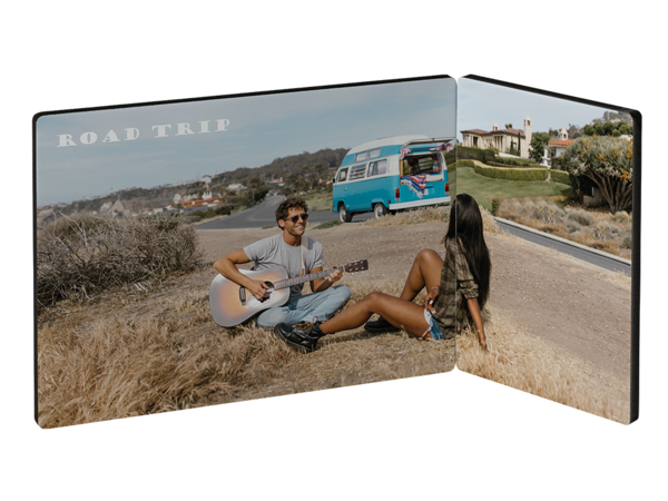Fotoaufsteller, zweiteilig: Roadtrip-Szene mit Gitarre spielendem Mann, Van und zuhörender Frau.